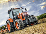 Orange and black tractor in a field with a scenic background